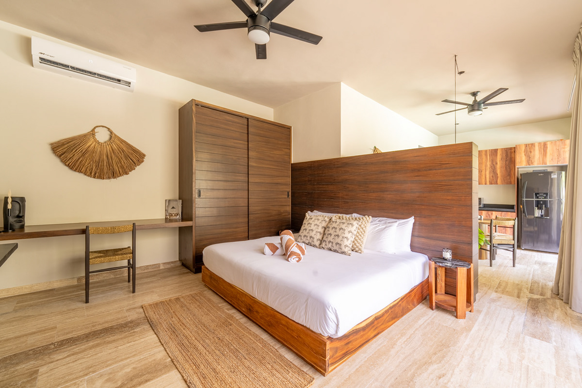 Bedroom with a wooden bed and divider beside the kitchen — Attha