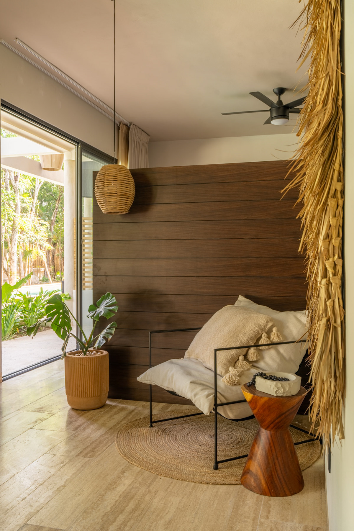 Living-room seating beside a large window and natural textures — Attha