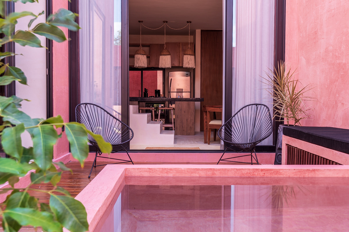 Pink pool courtyard opening into the interior living space — Casa Nikte