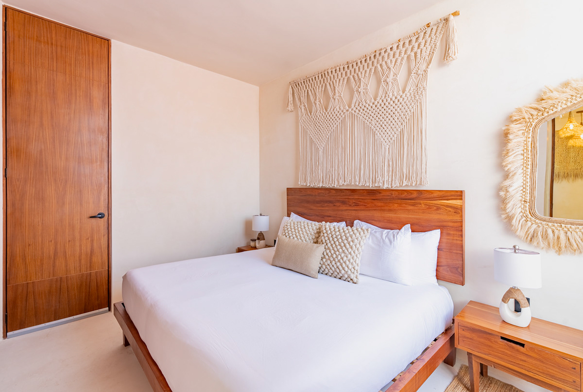Bedroom with a wooden headboard and natural woven details — Casa Nikte