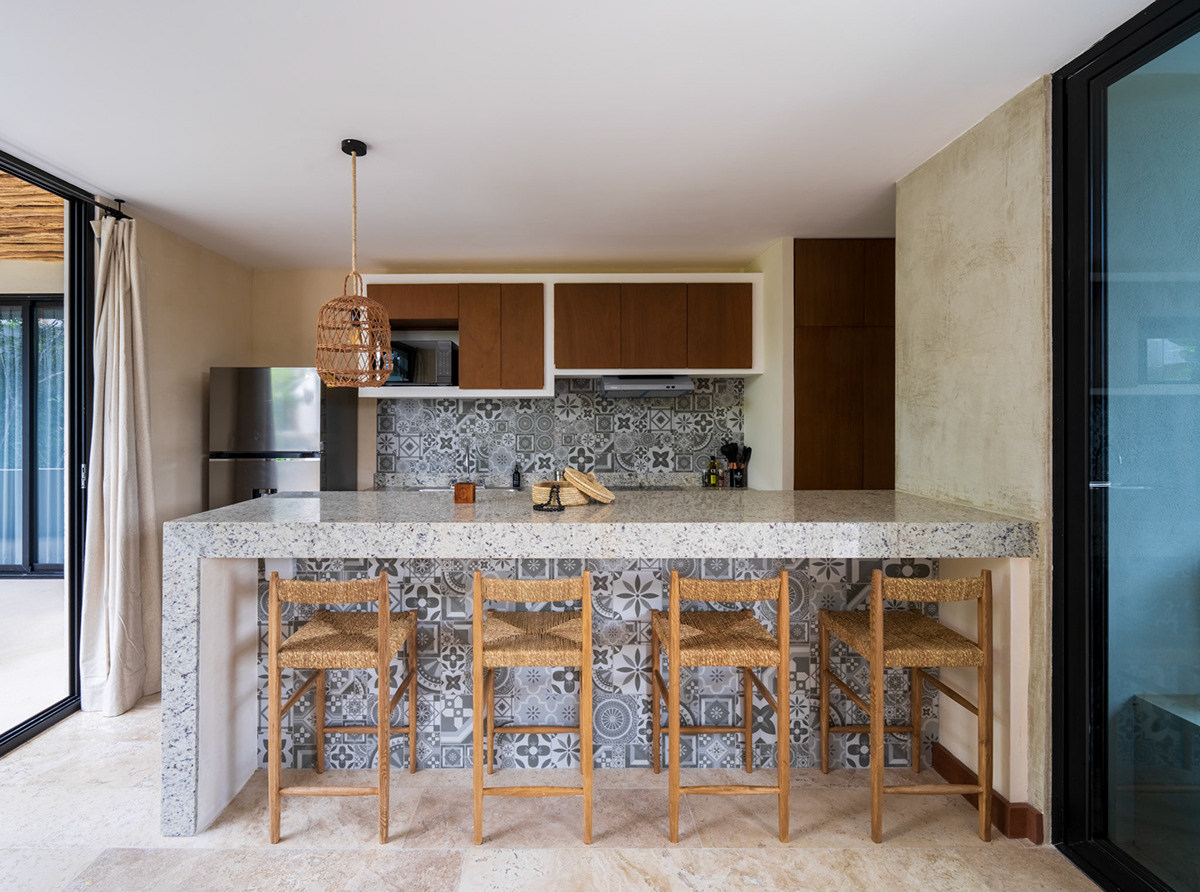 Open kitchen with a patterned breakfast bar and woven stools — Casa Noil 26