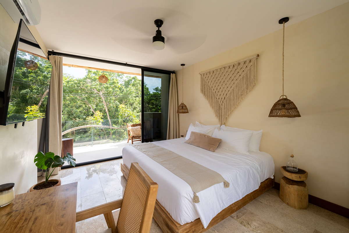 Bedroom opening toward the leafy courtyard — Casa Noil 26