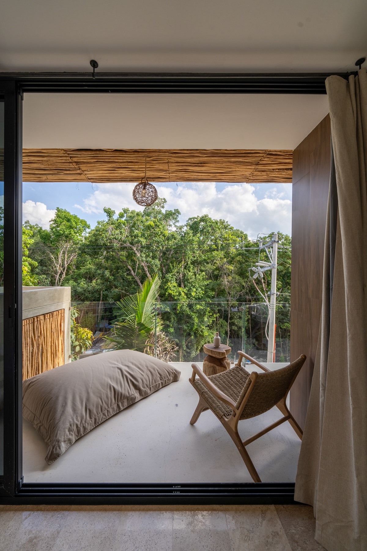 View through sliding glass doors to a shaded outdoor seating area — Casa Noil 27