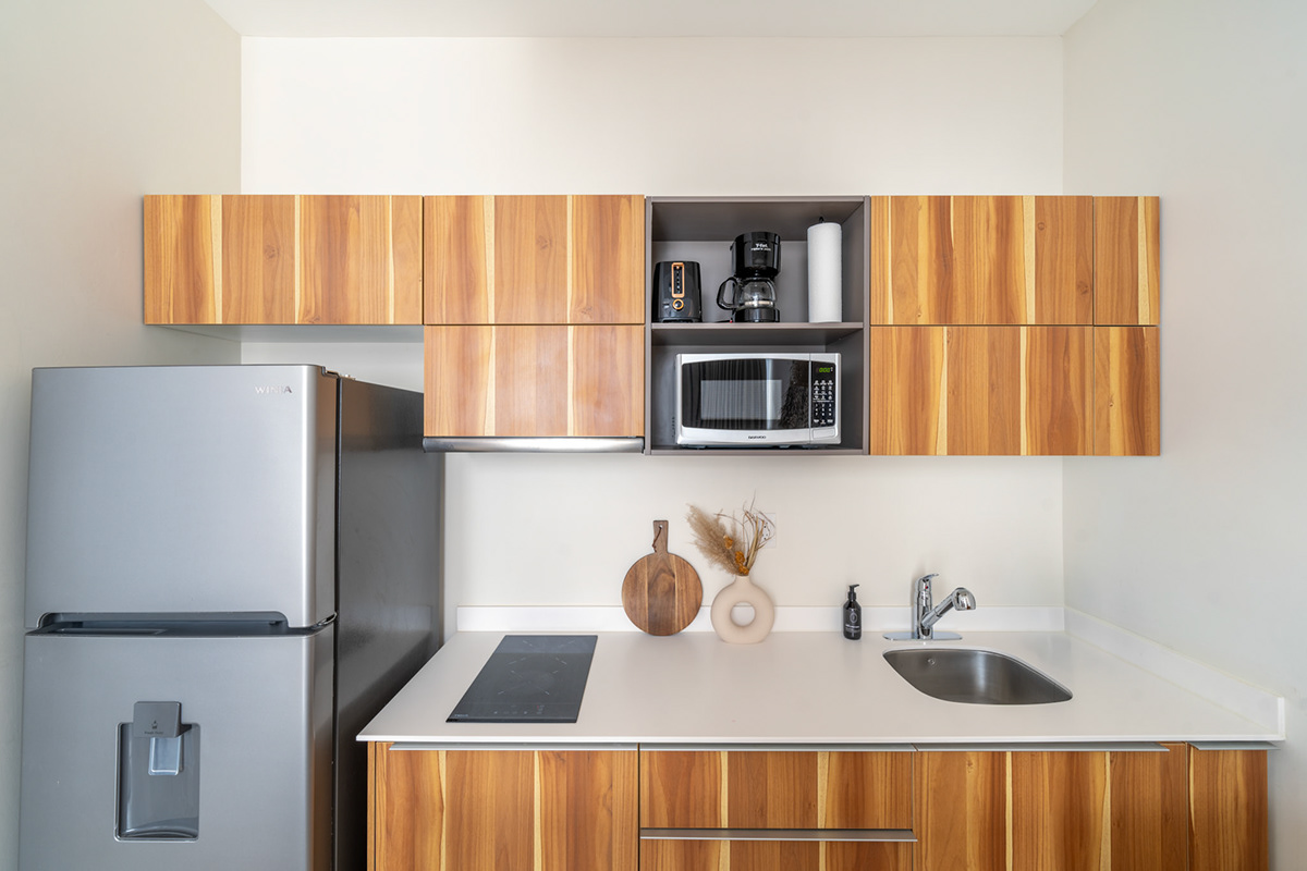 Compact kitchen with wooden cabinetry and open shelving — Elena
