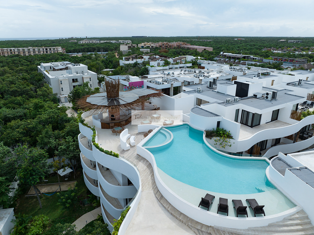 Aerial view of the curved rooftop swimming pool and surrounding residences — Hunab Residences