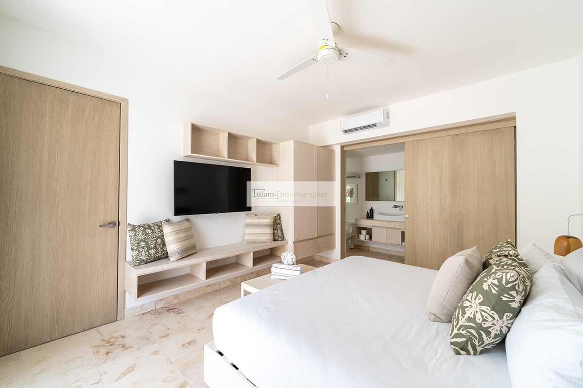 Bright studio interior with a bed, seating area, and pale wood cabinetry — Hunab Residences