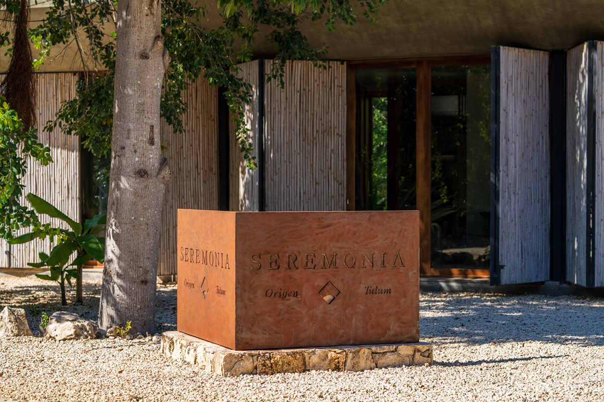 Entrance sign and textured concrete architecture at Seremonia Origen — Seremonia Origen