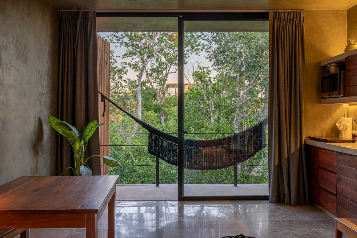 Hammock and garden-facing glass doors beside the dining space — Seremonia Origen