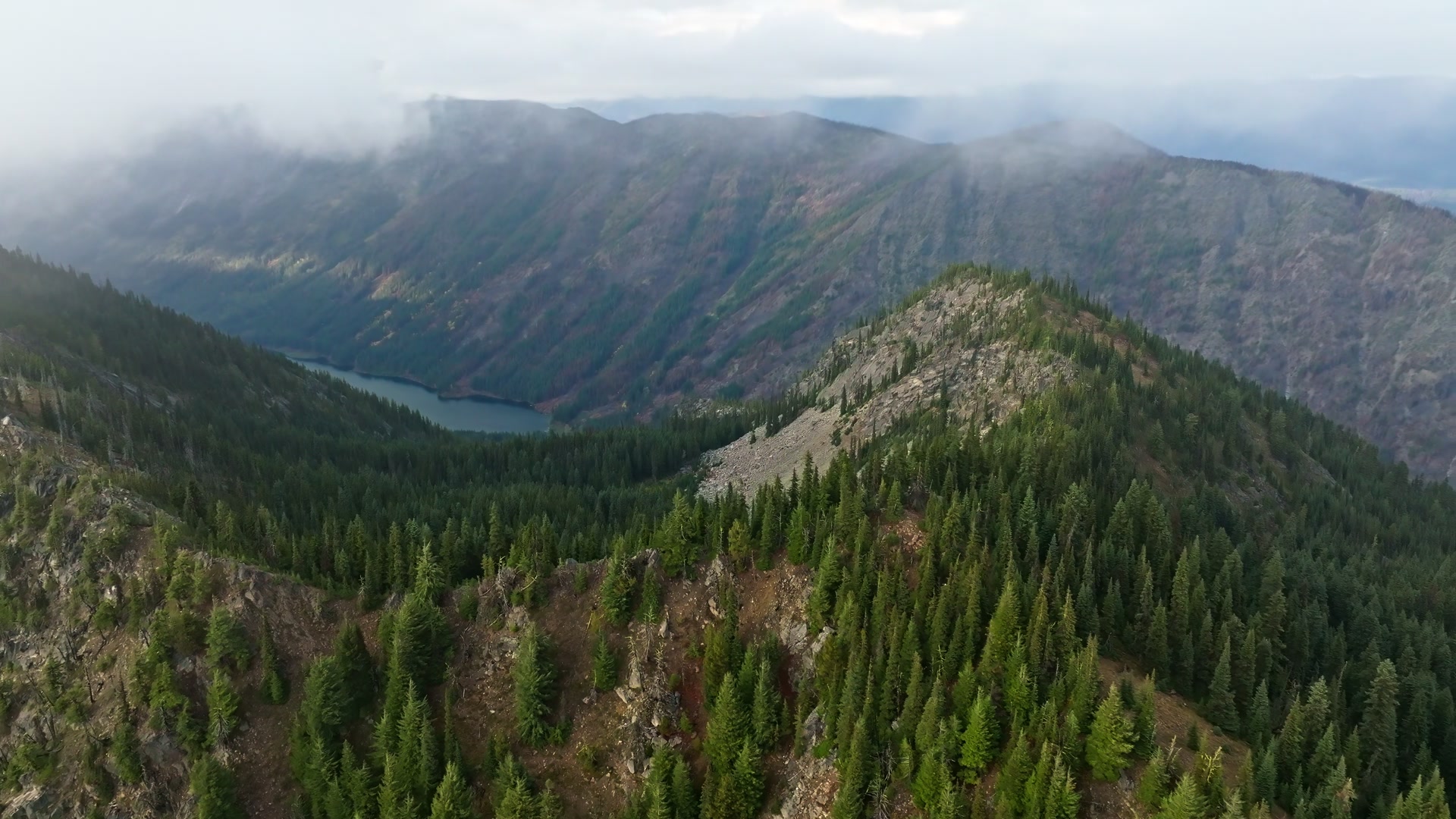 Cloud drifting over a forested ridgeline in the White River Valley aerial film